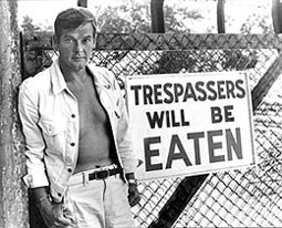 Roger Moore poses with sign on location for Live And Let Die
