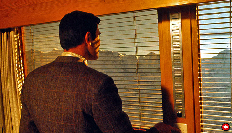 James Bond (George Lazenby) pulls the blinds in his Piz Gloria room