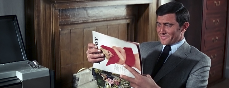 George Lazenby as James Bond looks inside the February 1969 issue of PLAYBOY in On Her Majesty's Secret Service (1969)