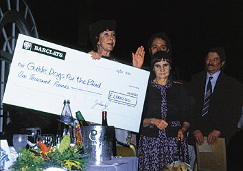 Lois Maxwell presents cheque at the 1993 JBIFC Christmas lunch
