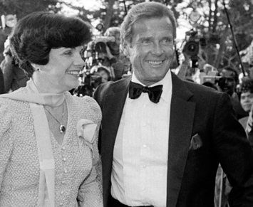 Mayor Dianne Feinstein with Roger Moore at the World Premiere of A View To A Kill held at the Palace of Fine Arts, San Francisco on May 22, 1985. (right) Moore signs autographs for the waiting fans as EON Productions Director of Marketing Jerry Juroe tries to move him on.